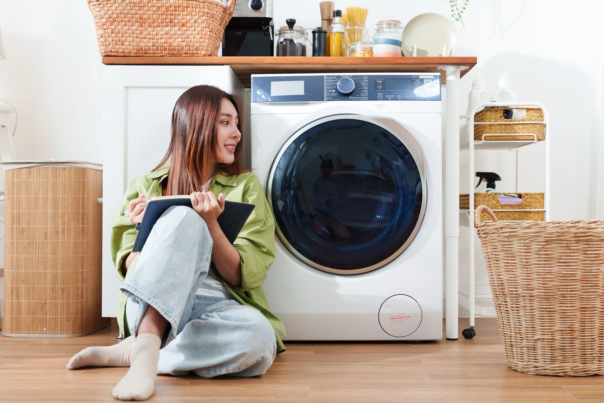 Homeowner beside a washing machine in a bright laundry room